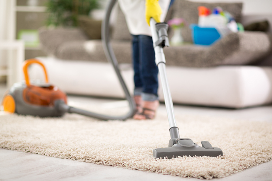 Close up of vacuuming carpet with vacuum cleaner