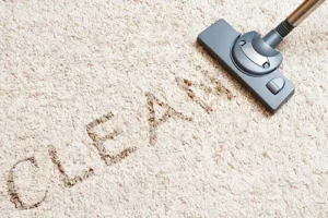 Sho-Me Carpet Cleaning—Dirt is in the carpet, spelling out the word clean with a vacuum next to it in a home in Branson, MO.