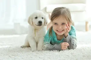 Sho-Me Clean Carpet Cleaning—Young girl lying next to a puppy on a clean rug in a home in Branson, MO.